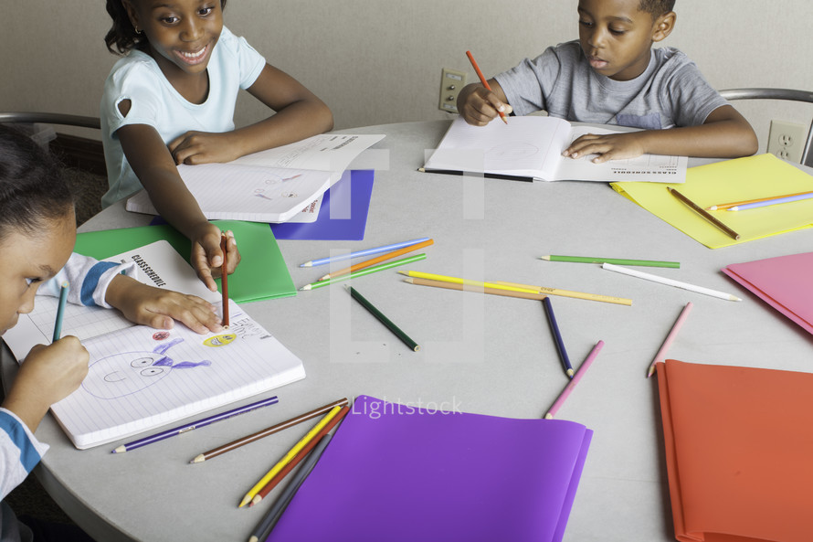 kids coloring around a table 