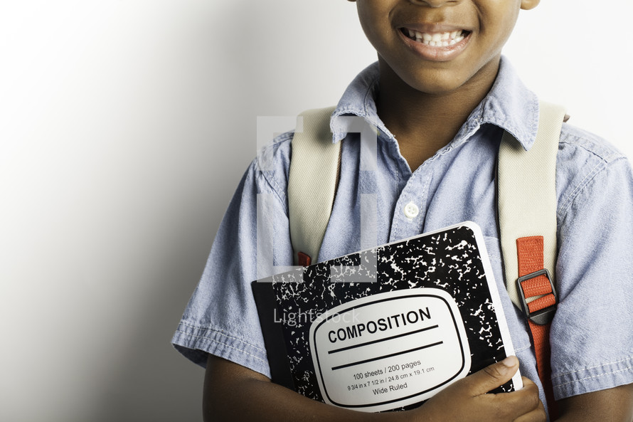 a boy child holding a composition notebook 