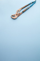 Crescent wrench at the top of a blue background.