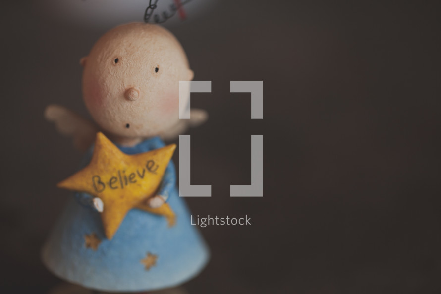 A Christmas doll with a star that says believe