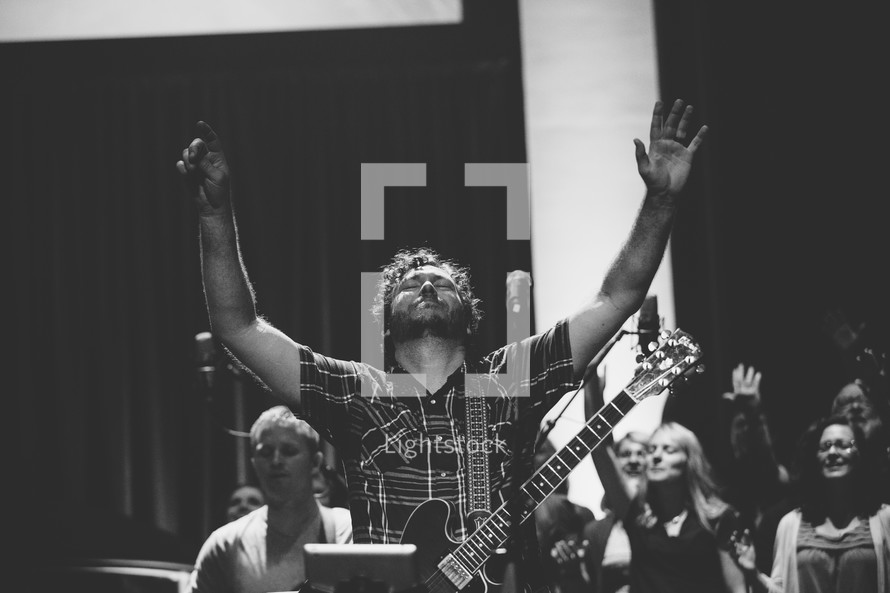 a man with raised hands in worship 