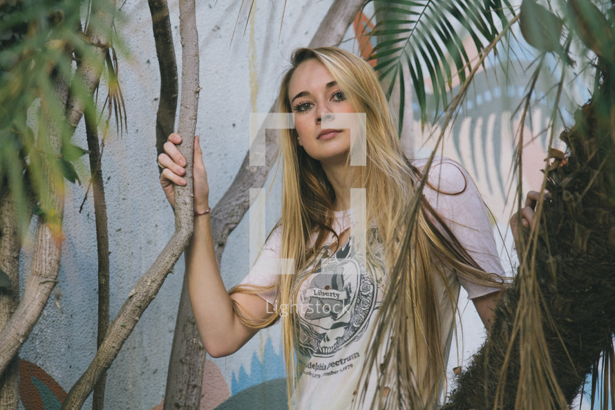 portrait of a blonde woman in a tropical plants 