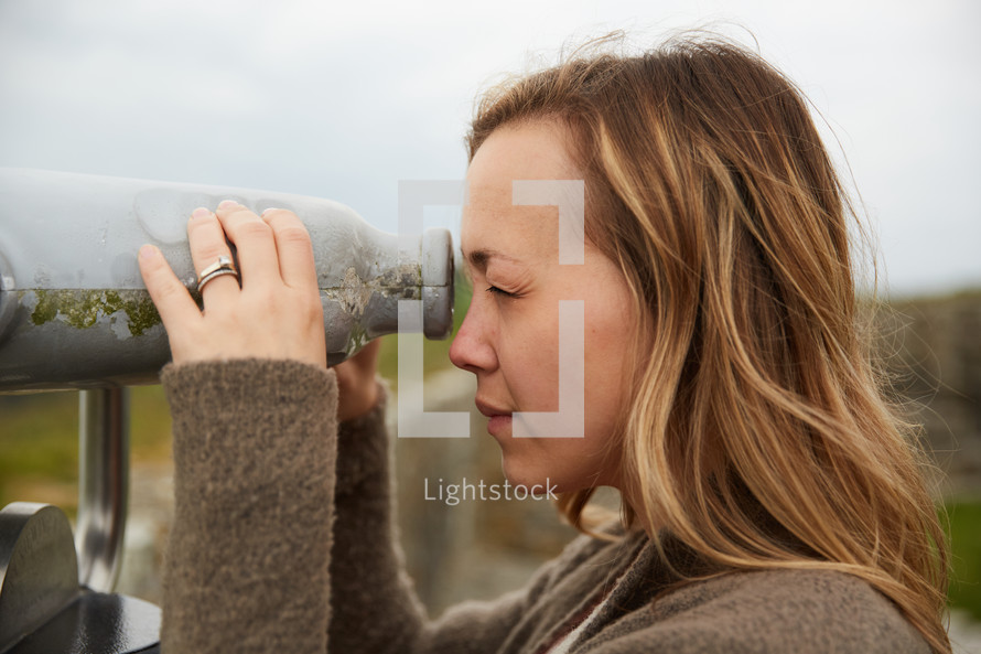 a woman looking through a viewfinder scope 