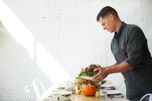 a man putting a turkey on a table 