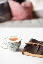 cinnamon heart in a coffee cup, Leather bound Bible, and couch