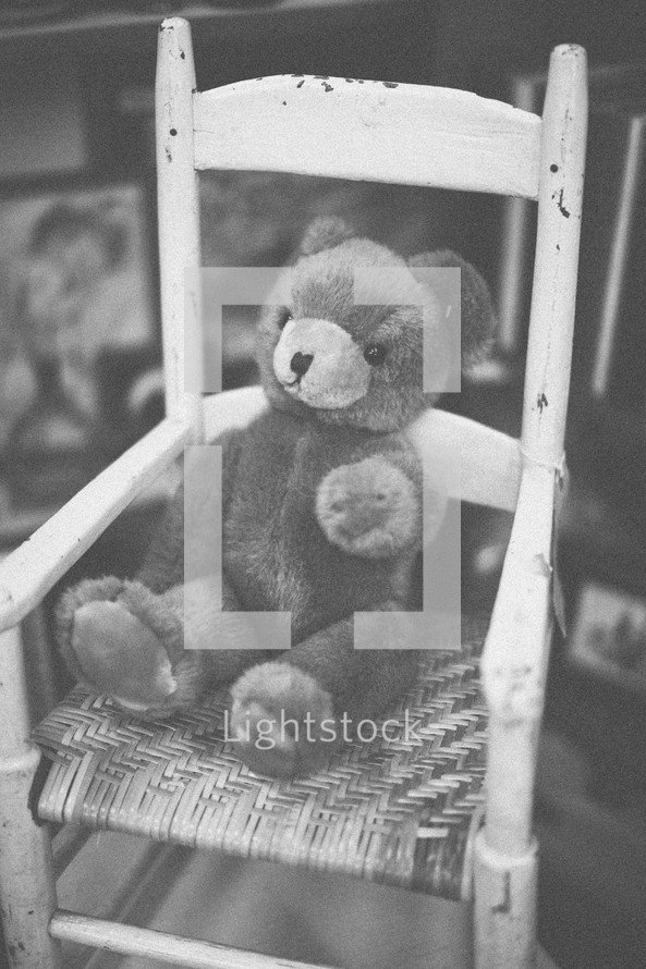 A teddy bear sitting in a rocking chair
