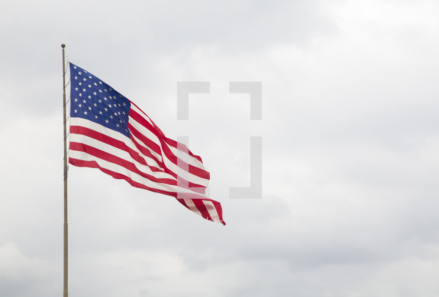 American Flag with a Blue Cloudy Sky
