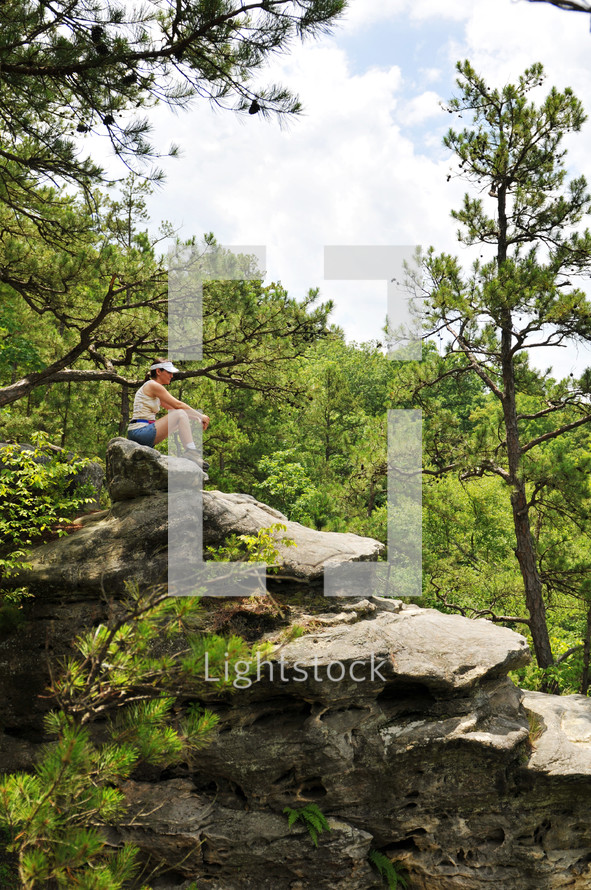 woman sitting at the top of a mountain 