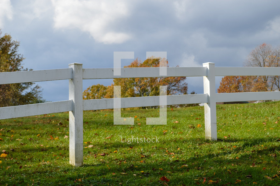 white fence on a rural autumn landscape 