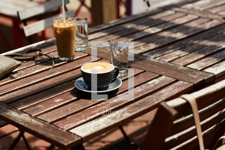iced coffee and cappuccino on a wooden table outdoors 