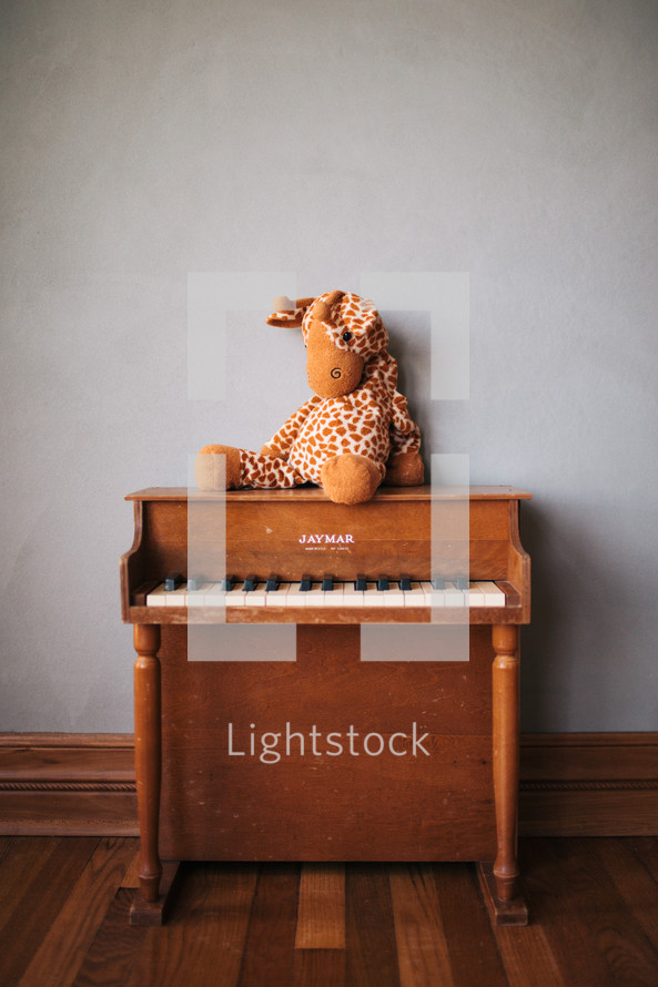 stuffed animal giraffe and a kids piano 