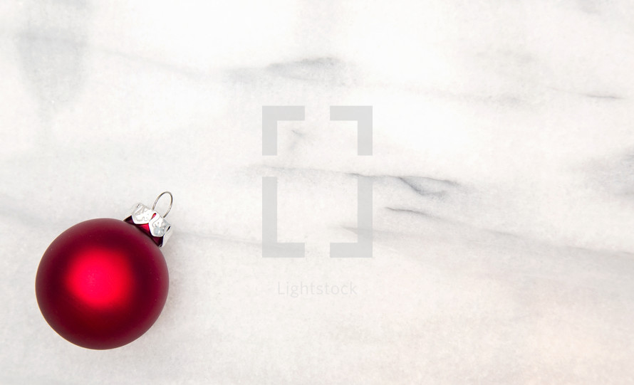 single red ornament on marble 