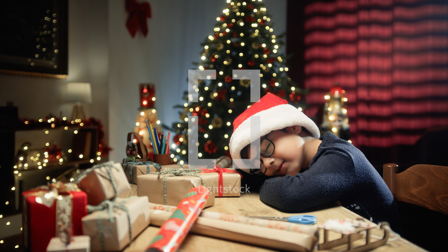 little boy yawning and falling asleep on his desk in Christmas