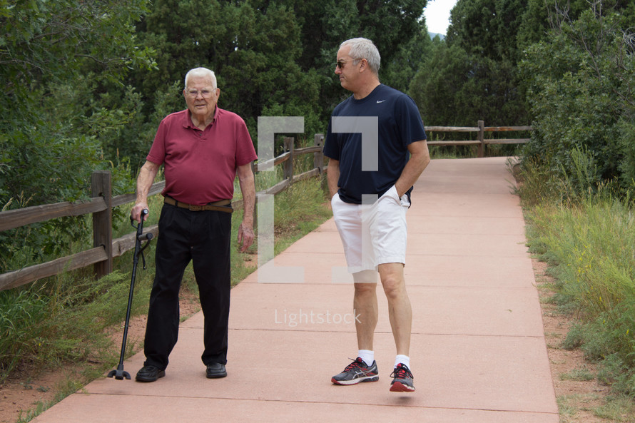 father and son walking together on a path 