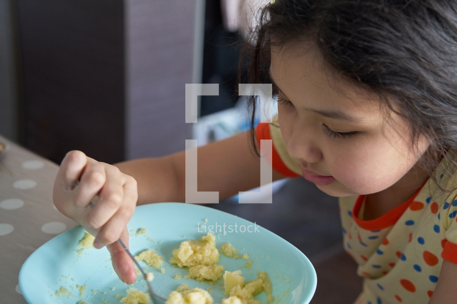 Girl having breakfast and eating eggs
