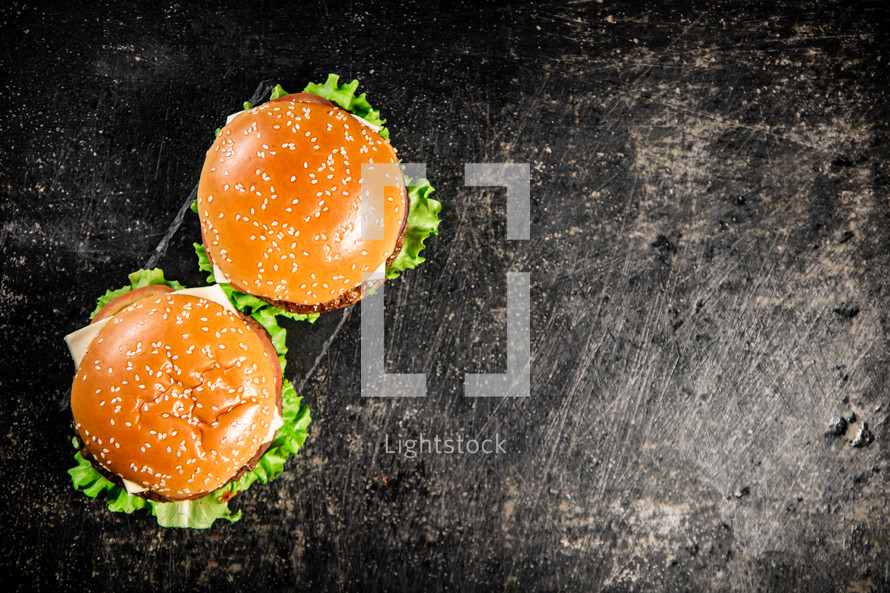 A burger on a stone board on a table. On a black background. High quality photo