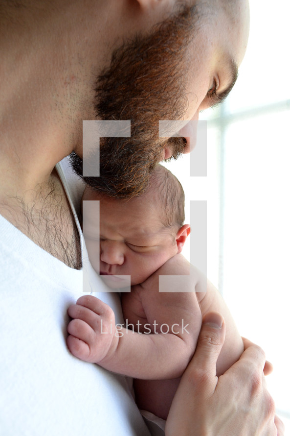 a father cradling a newborn 
