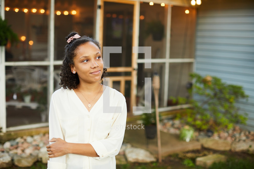 a young woman standing on a porch looking up to God 