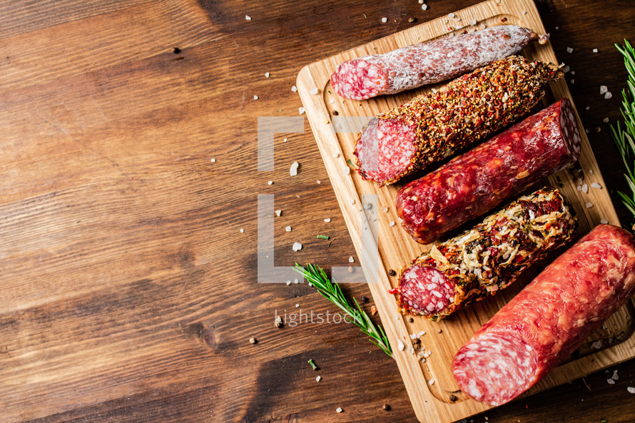 Assortment of various aromatic salami sausages. Against a dark background. High quality photo