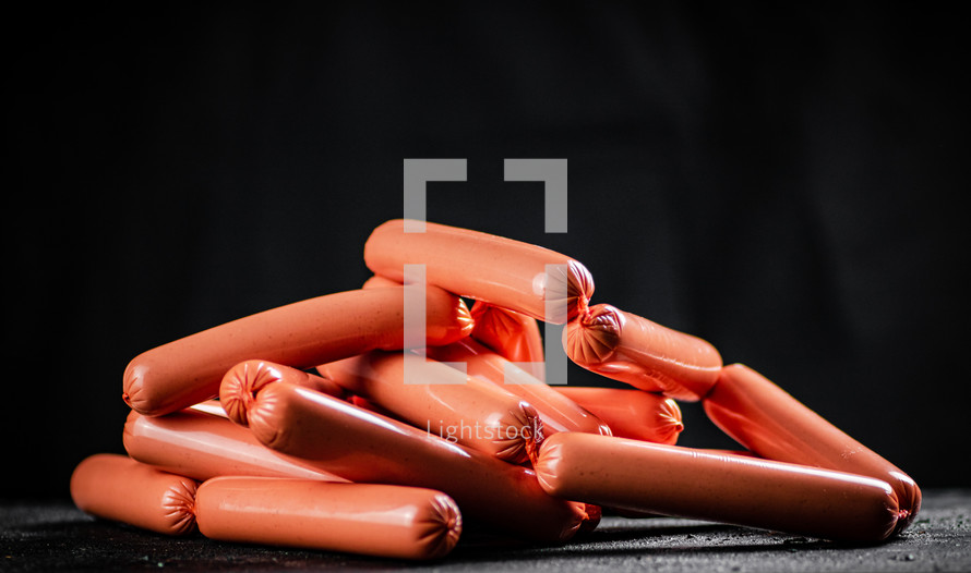 Delicious sausages boiled on the table. On a black background. High quality photo