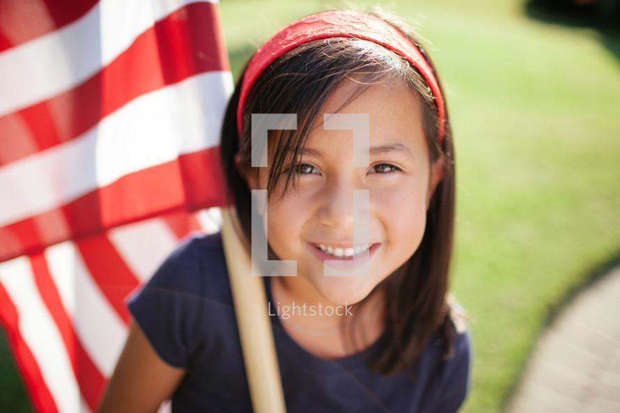 girl child holding an American flag 