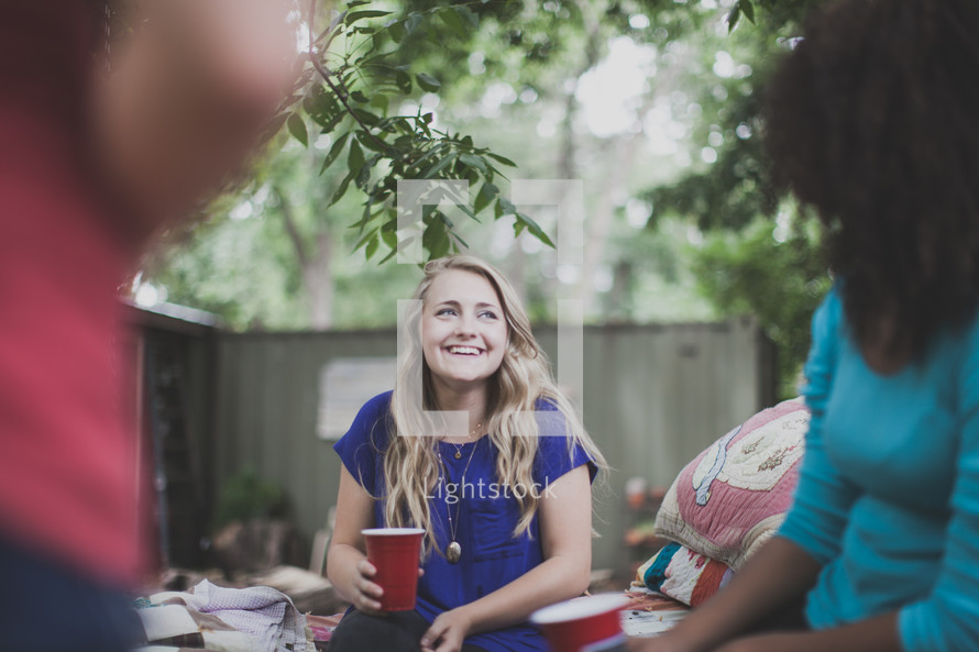 friends holding cups and in conversation at a cookout 