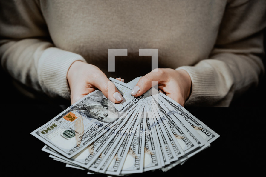 Woman holding hundreds of dollars
