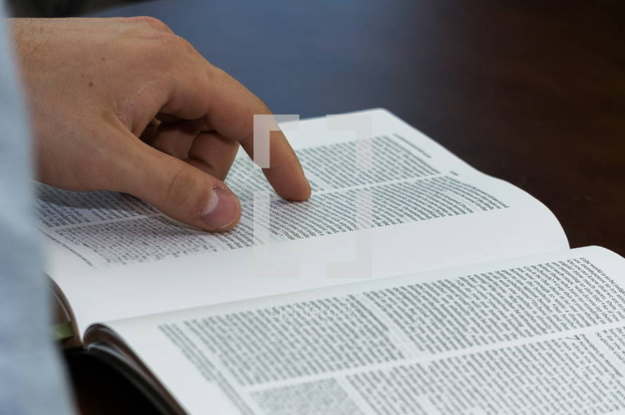 a man pointing to scripture in a Bible 