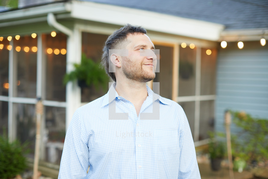 a man standing outdoors in a back yard 