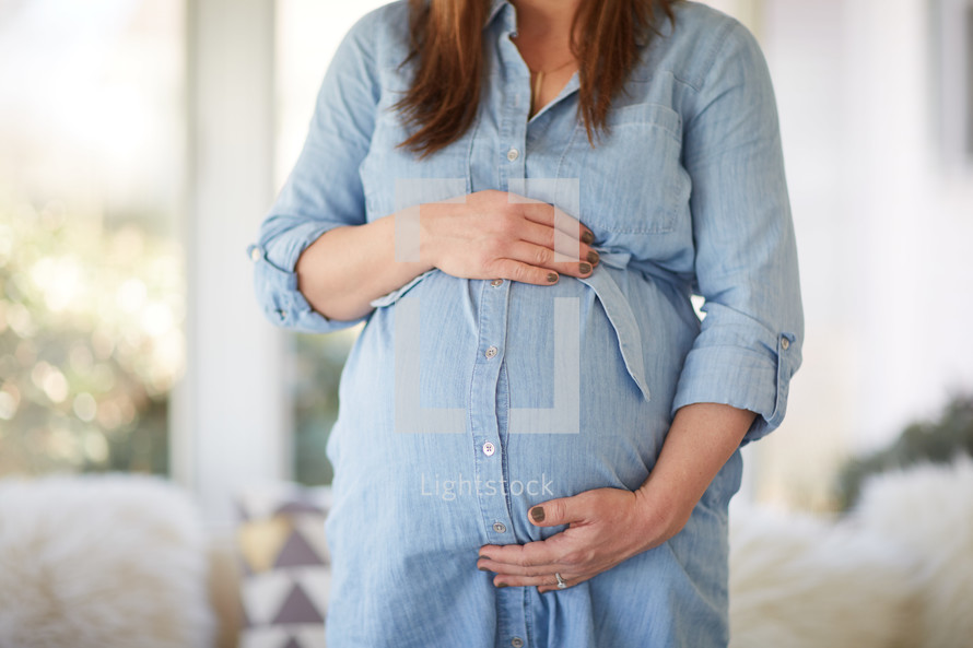 pregnant woman holding her belly 
