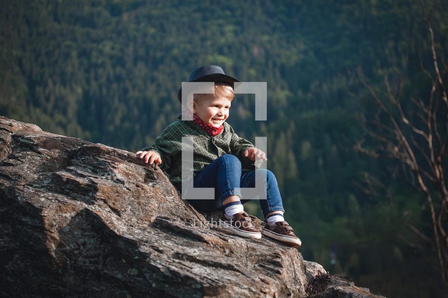 Cute Little Smiling Happy Boy with Hat and Bandana in Rocky Mountains