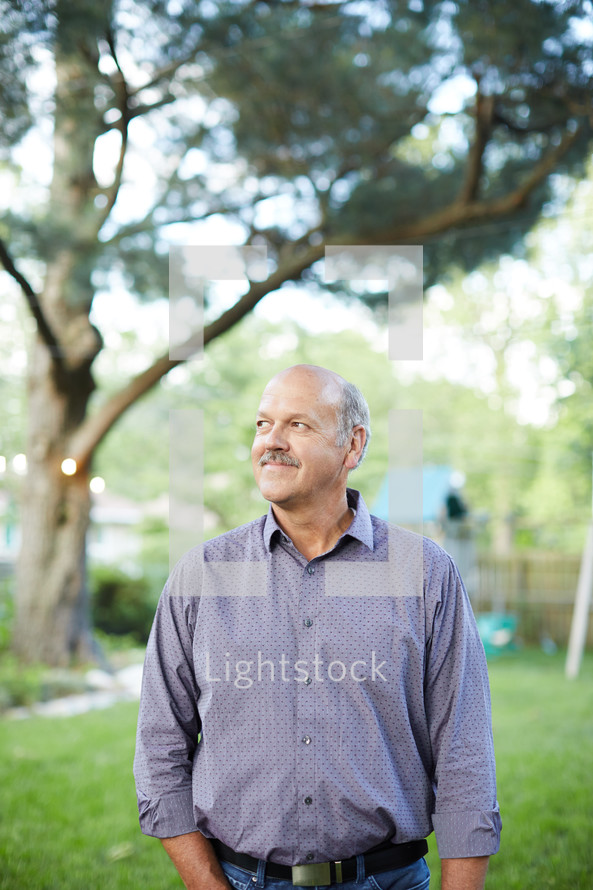 man standing outdoors looking to his side 