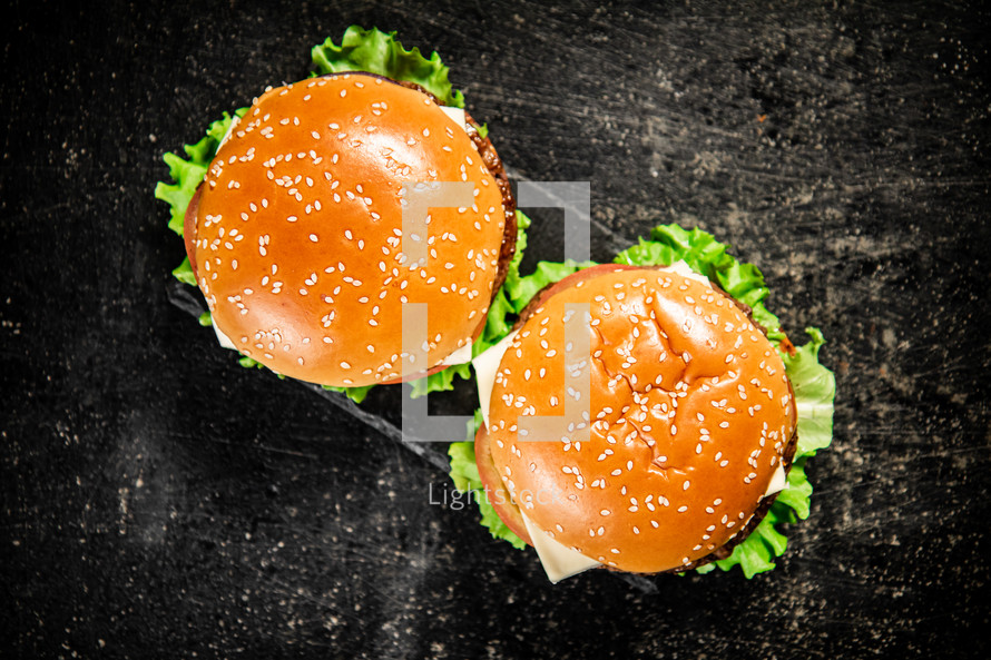 A burger on a stone board on a table. On a black background. High quality photo