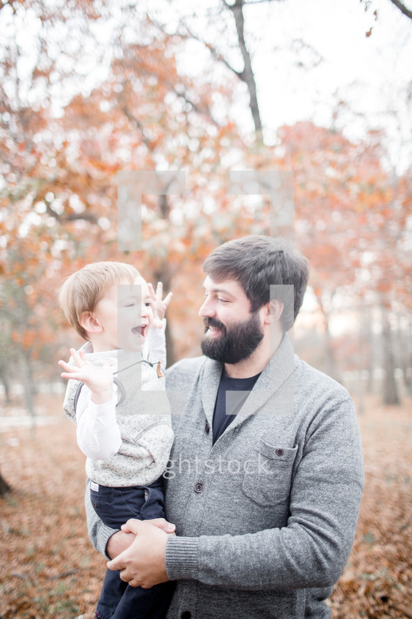father holding his son outdoors in fall 