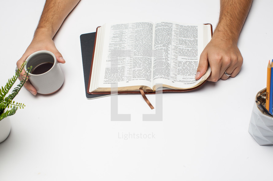 a man at a desk reading a Bible 