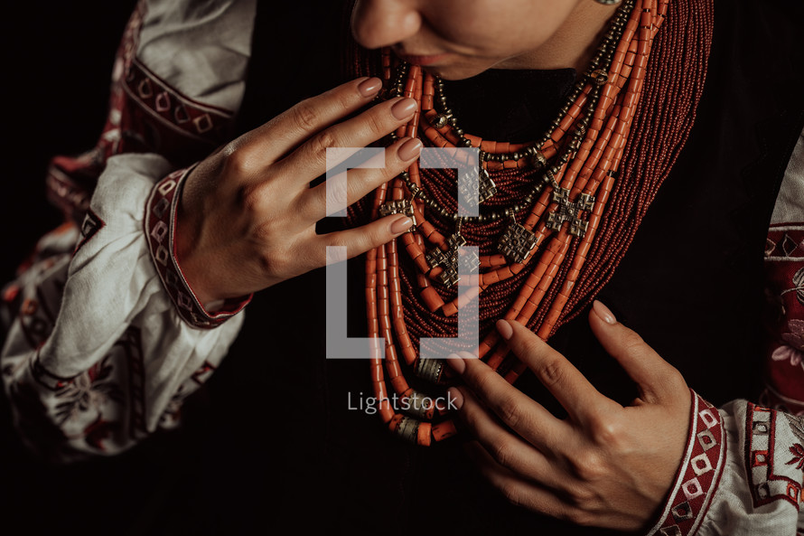 Demonstrating traditional antique jewelry necklace. National costume of Ukraine. Ukrainian woman in legacy ancient coral beads, Zgarda - archaic hutsul neck ornament of status religious purpose.