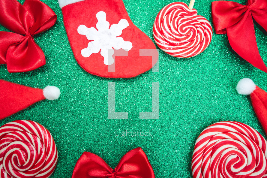 Flatlay of some red Christmas decoration, on a green background. Background for Christmas.