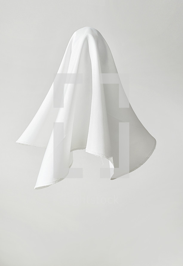 White fabric in shape of a ghost on white background
