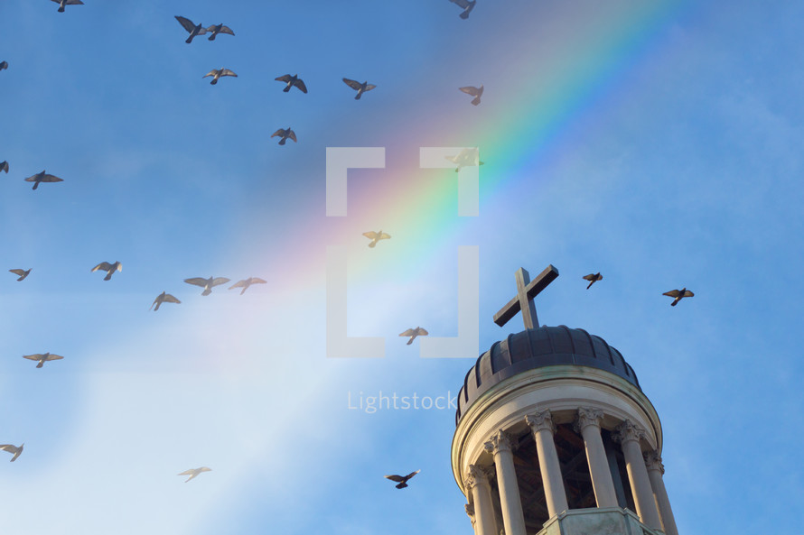 doves flying over a steeple and rainbow 