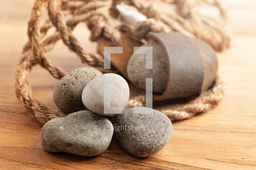 A Sling Shot and Stones on a Wooden Table from the Story of David and Goliath in the BIble 