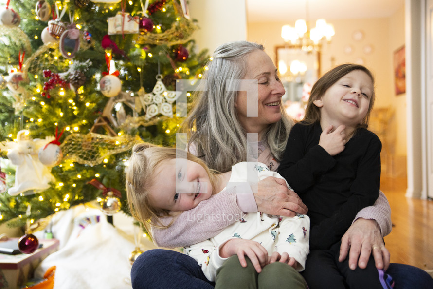 Grandmother with girls in front of Christmas tree