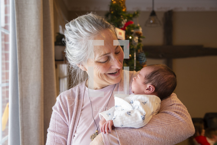 Grandmother holding newborn baby and smiling