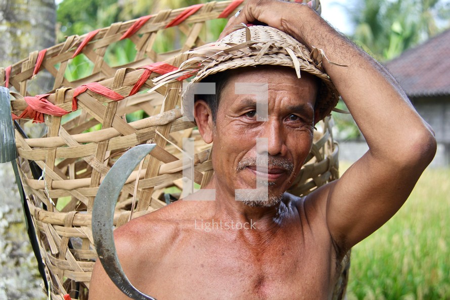 a man carrying a straw basket and machete 