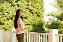 a woman standing on a back porch 