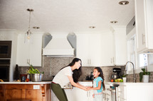 mother and daughter dancing in a kitchen 