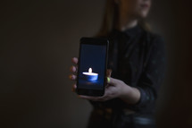 girl holding image of candle in dark room