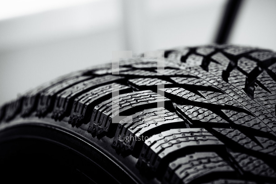 new car tire background. close up of texture. Stack of brand new high performance car tires on clean high-key white studio background
