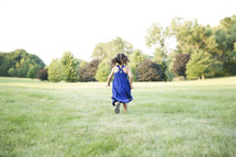 toddler girl running in the grass 