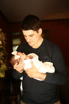 a father holding his newborn infant 