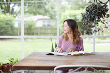 a woman reading a Bible on her porch 